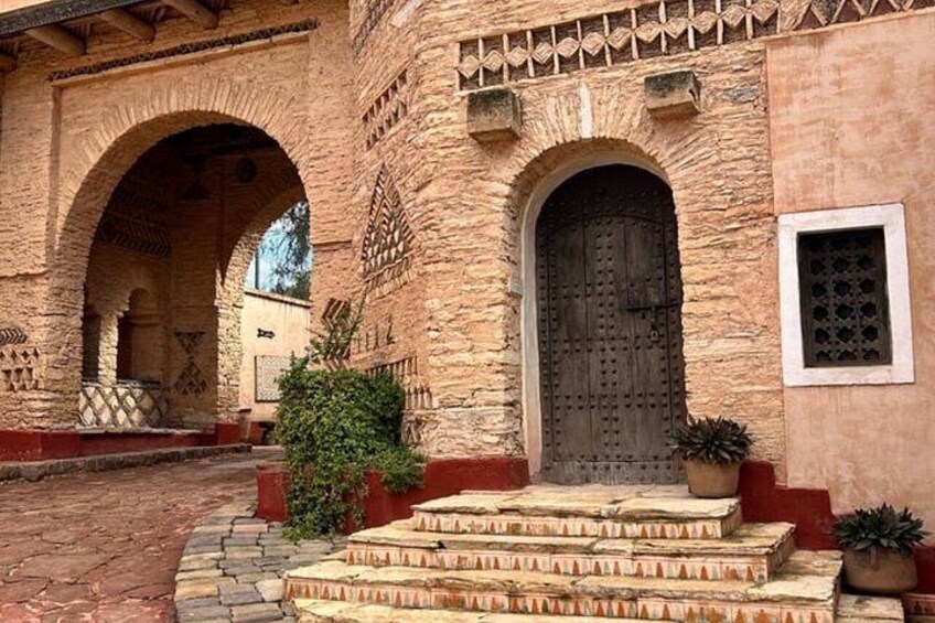 A stone building with a wooden door and arched windows. 3