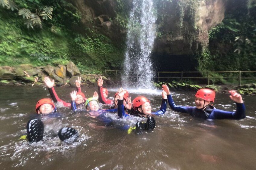 People rafting in a river with a waterfall in the background. 2