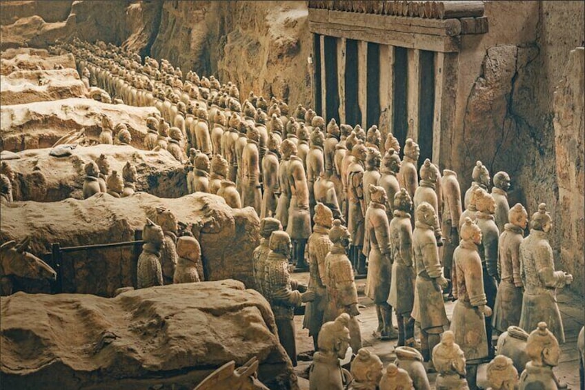A large number of terracotta soldiers lined up in rows, a tomb complex, and a large stone structure. 1