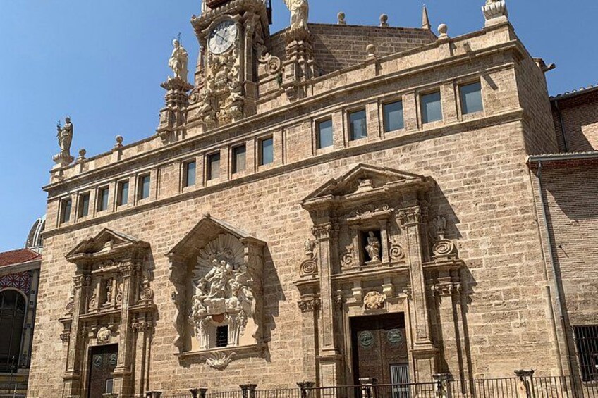 A historic building with ornate architectural details, including a clock tower and statues. 2