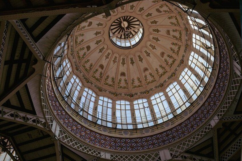 A grand, ornate ceiling with intricate patterns and a central clock. 1