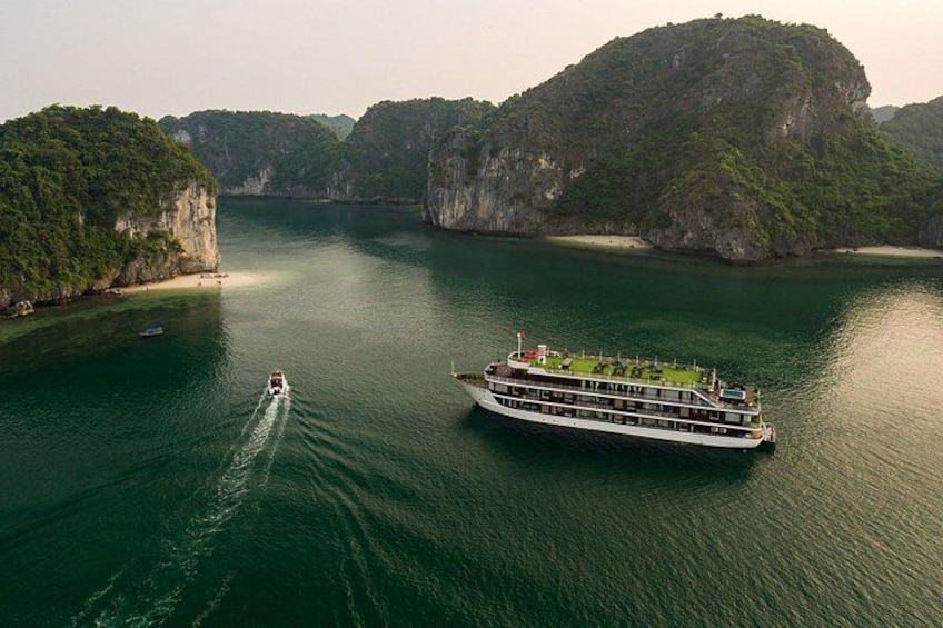 Un gran crucero navega por un río tranquilo, rodeado de imponentes acantilados verdes. 1