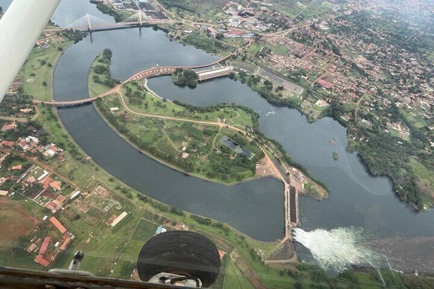 A river winding through a town with a bridge crossing over it. 1