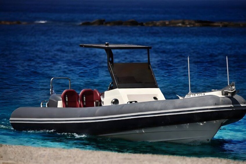 A small motorboat with a canopy, red seats, and a registration number on the back. 2