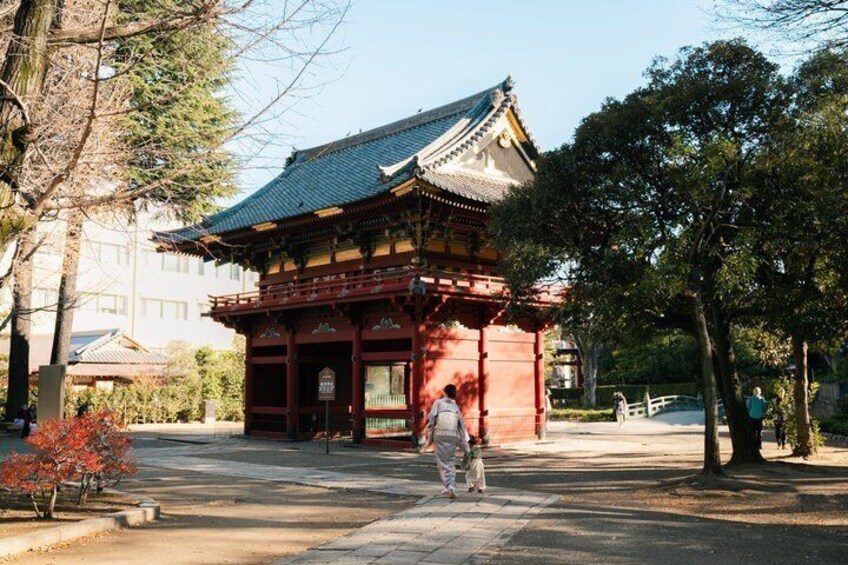 Een traditioneel Japans gebouw met een betegeld dak en rode houten constructie. 1