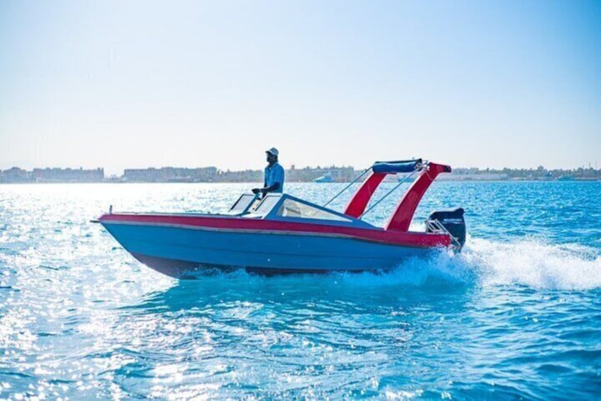 Een speedboot op het water met een bestuurder, een heldere lucht en een verre kustlijn. 2