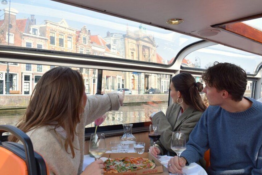 People dining on a boat with a view of historic buildings. 3