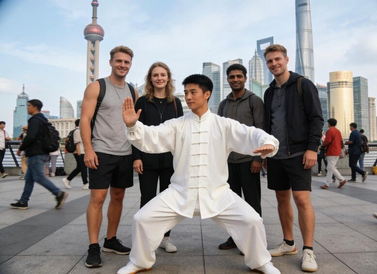A group of people in a city square with modern buildings and a tower in the background. 4