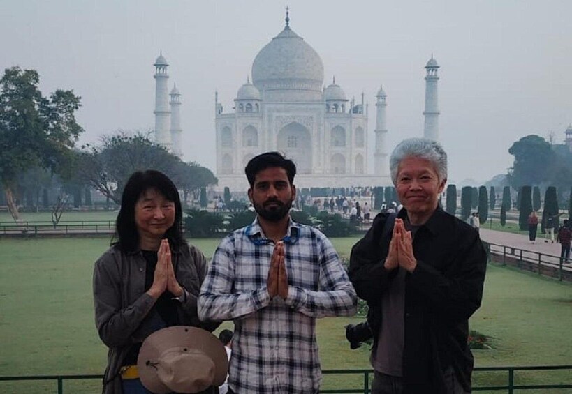 Three people in front of the Taj Mahal. 1