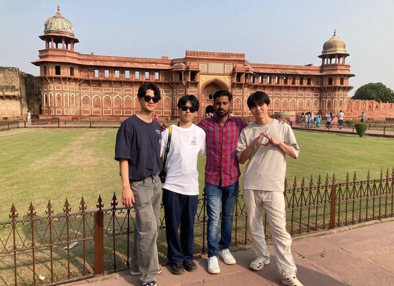 A group of people standing in front of a large, historic building with domes and arches. 3
