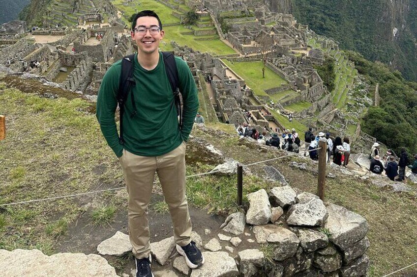 A person standing on a stone pathway with ruins in the background. 4