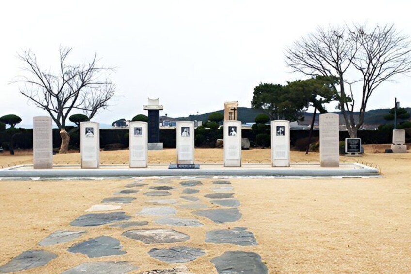 A memorial with stone slabs and a paved pathway. 3