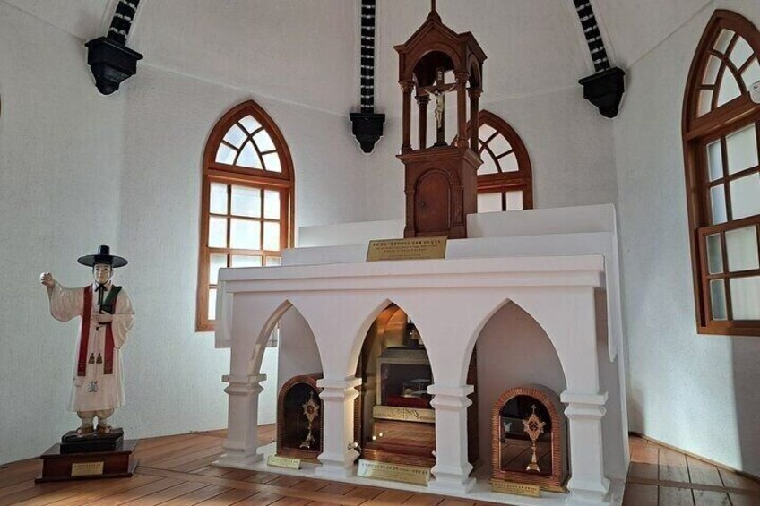 A church interior with arched windows, a wooden clock, and a statue. 5