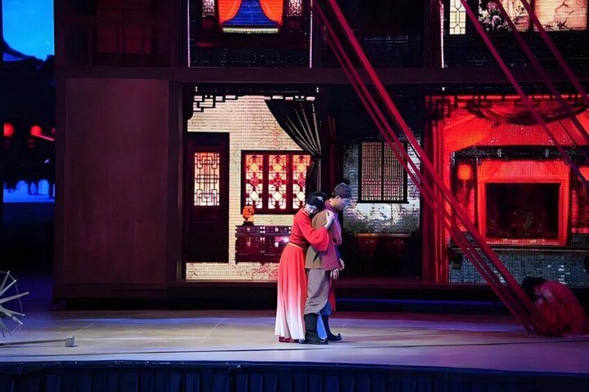 A stage with a traditional Chinese architectural backdrop, a couple in traditional attire, and a red-lit staircase. 3