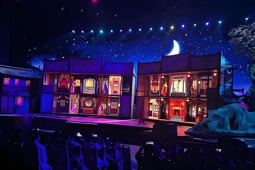 A nighttime outdoor theater with illuminated buildings and a starry sky. 4