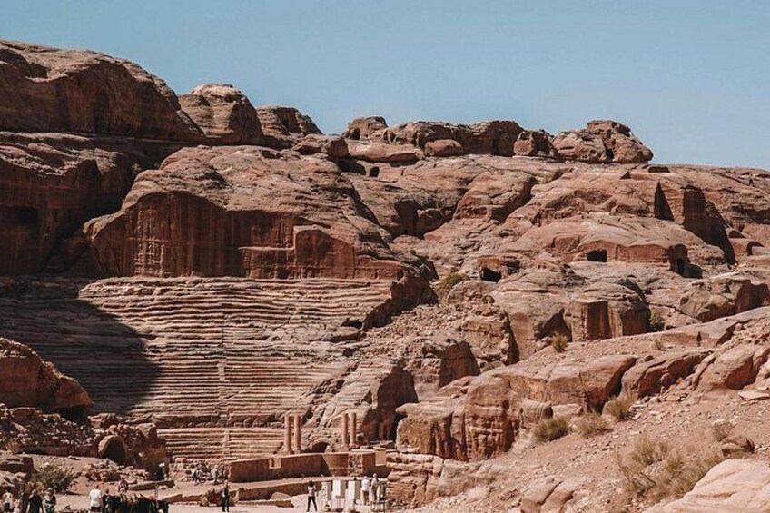 Une vaste formation rocheuse présentant des structures sédimentaires en couches et une série de niches sculptées. 3