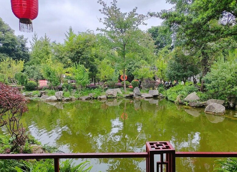A tranquil garden with a pond, rocks, and various trees. 4