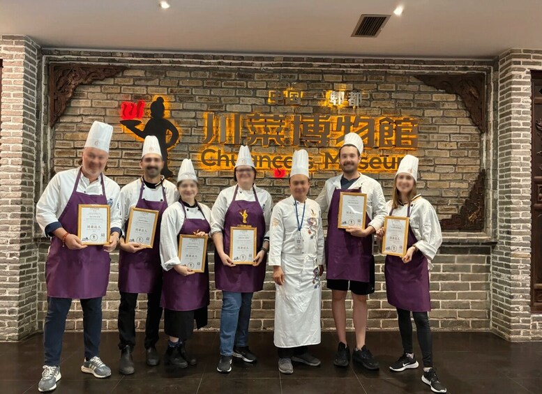 A group of people in chef uniforms standing in front of a brick wall with a sign that reads 'China Chef Museum.' 3