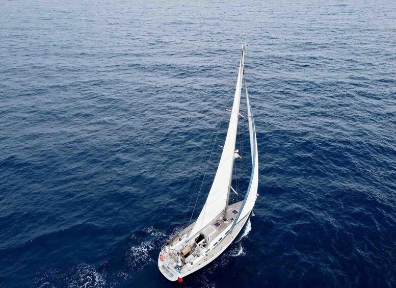 A sailboat with a long, white sail on the water. 2