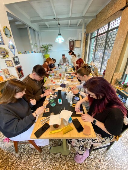 A group of people engaged in a craft activity at a table with various crafting materials. 3