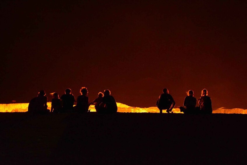 Silhouettes of people sitting on a beach at night. 4