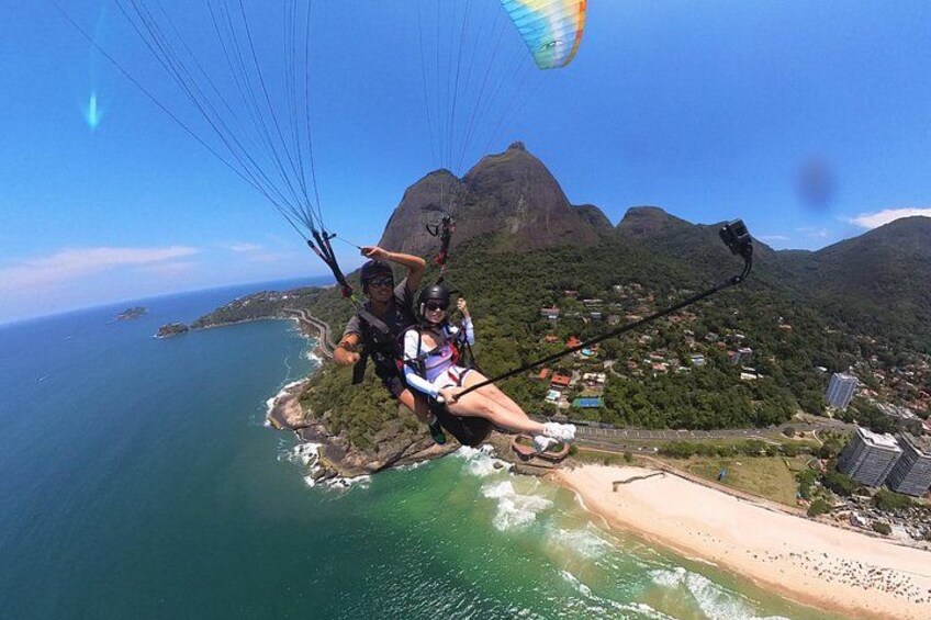 A person paragliding over a coastal area with a mountain in the background. 2