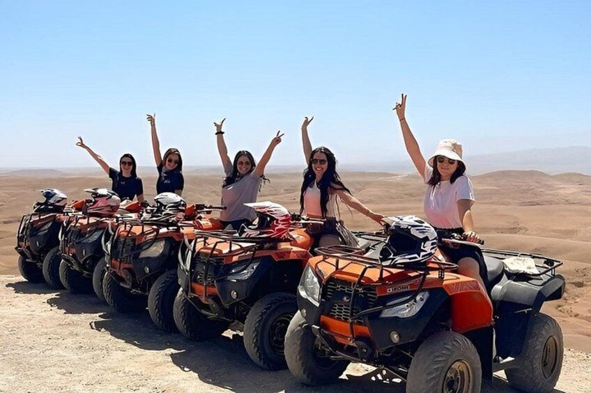Four people on ATVs in a desert landscape. 3