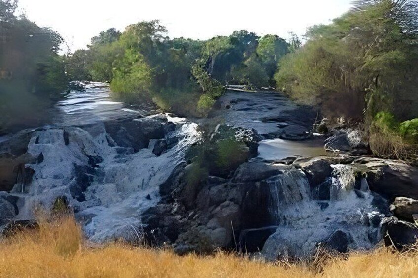 A waterfall cascading over rocks in a forested area. 3