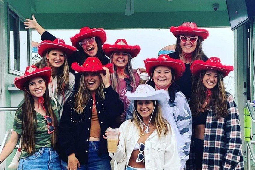 Un grupo de personas con sombreros rojos de pie en un barco. 2