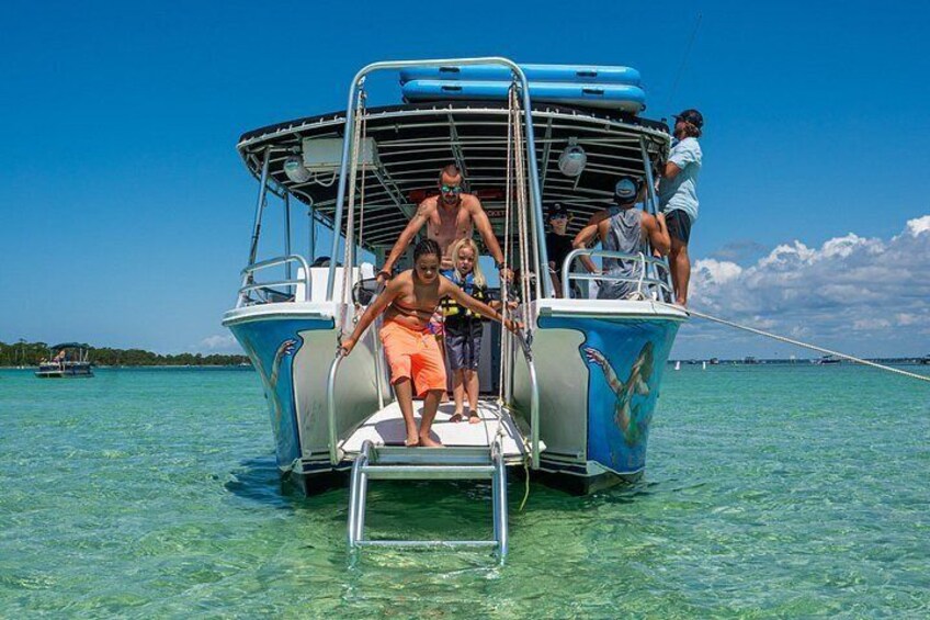 A boat with people boarding, clear turquoise water, and a distant shoreline. 2