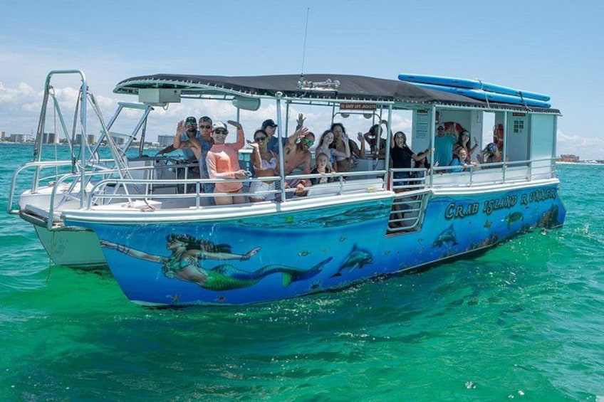 Un bote con diseño de sirena, identificado como 'CRAB ISLAND RANGER,' sobre aguas turquesas. 1