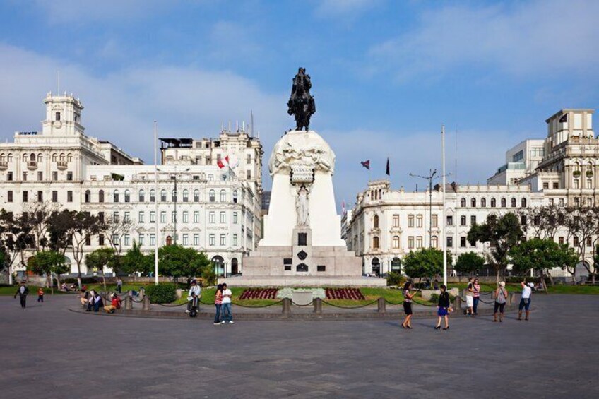 A large open plaza with a central monument, surrounded by historic buildings. 3