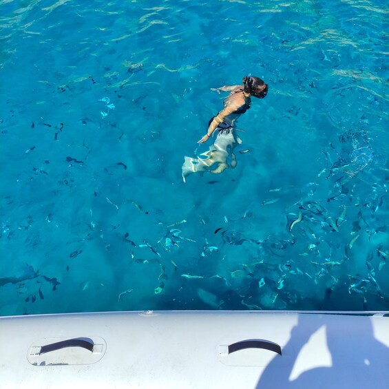 A person swimming in clear blue water. 5