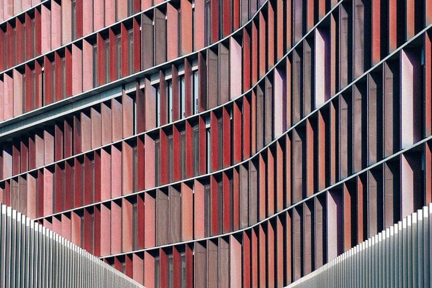 A modern building facade with vertical slats and a curved metal structure. 4