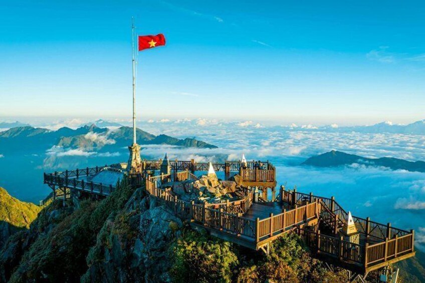 A high vantage point with a flag, wooden structures, and a mountainous landscape. 2