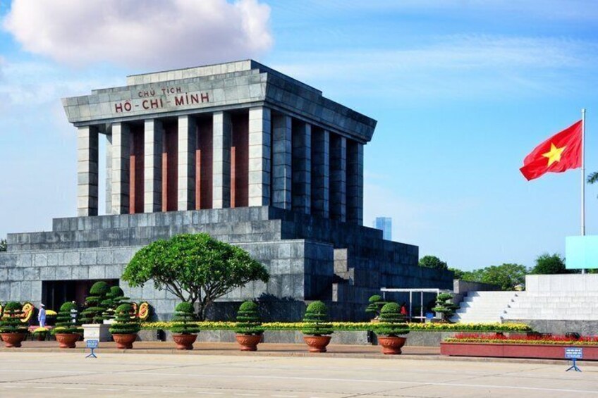 A large building with columns, a flag, and a tree in front. 4