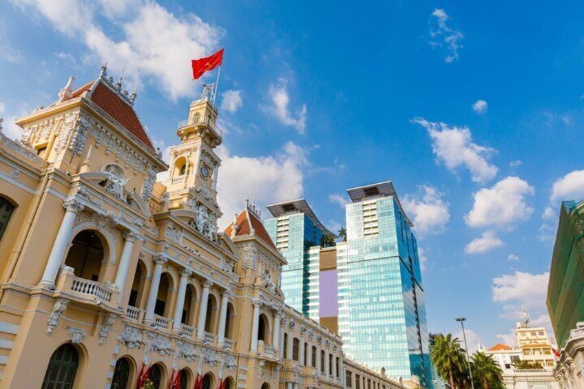 A historic building with ornate architecture and a modern skyscraper in the background. 1