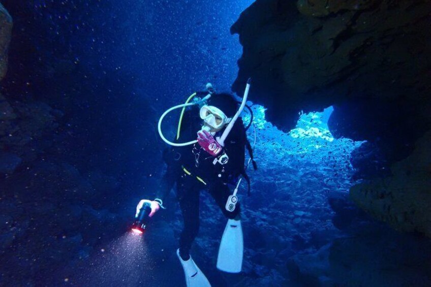 A diver in a cave with a flashlight. 1