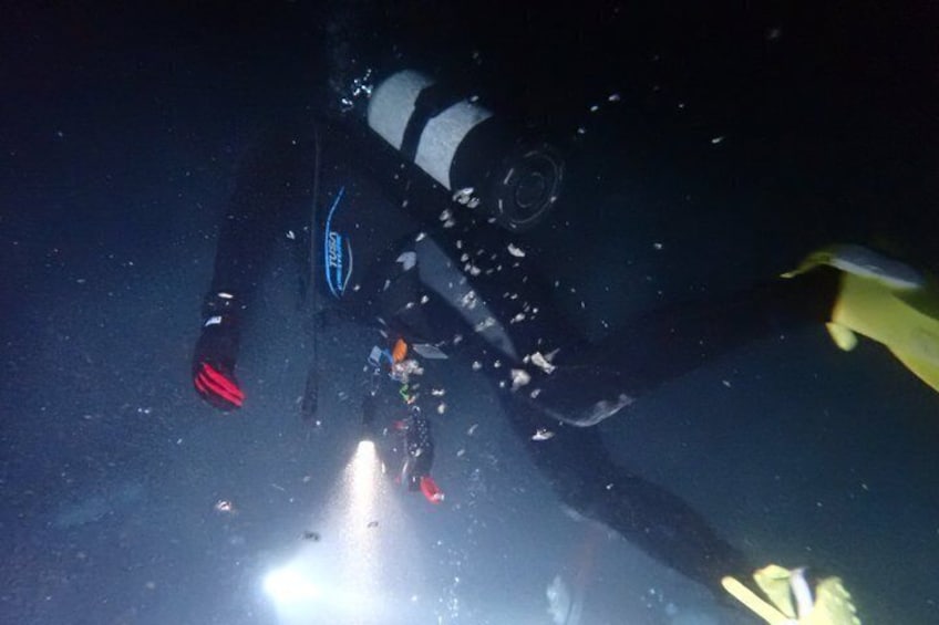 A diver with a camera, underwater bubbles, and a yellow object. 4