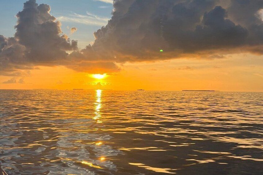 A sunset over a calm sea with clouds reflecting on the water. 2
