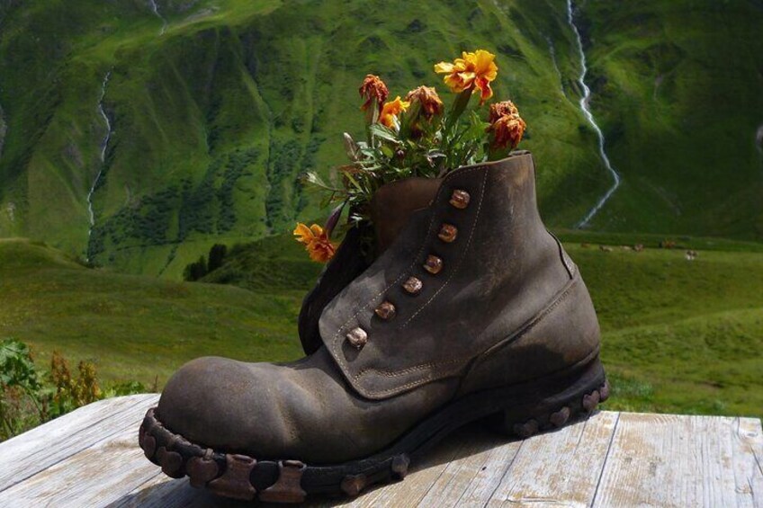 A brown boot with flowers on a wooden surface. 4