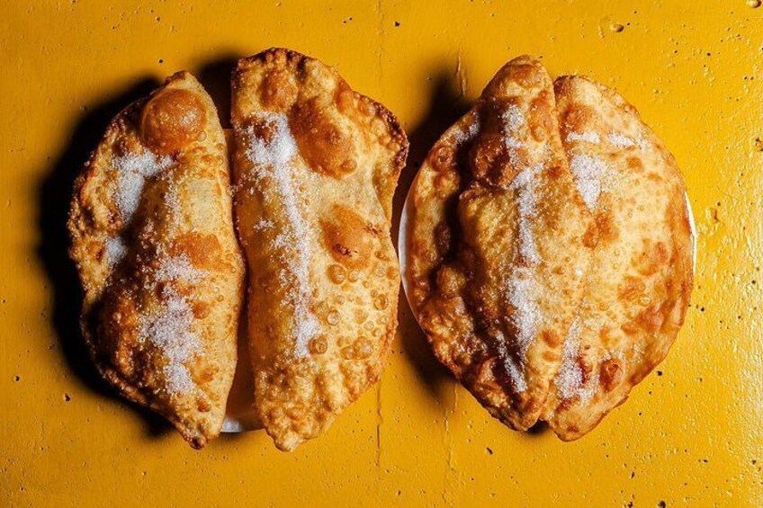Two fried pastries on a yellow surface. 2