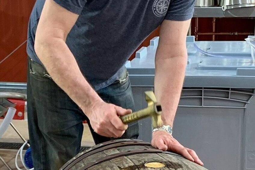 A person using a hammer on a large wheel. 2