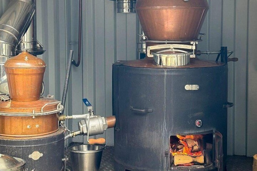 A large industrial boiler with a copper funnel and a metal pipe connected to it. 5