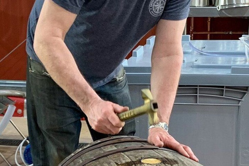A person using a hammer on a large tire. 2