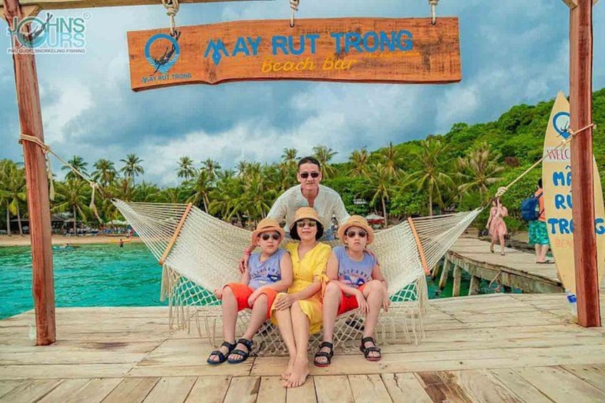 Una familia sentada en una hamaca en el bar May Rut Trong Beach Bar. 2