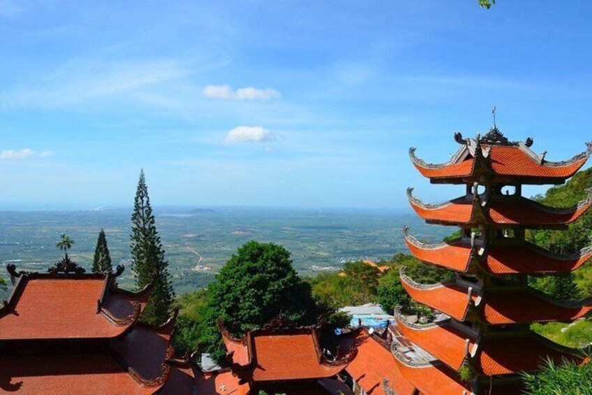 A pagoda with multiple tiers, surrounded by lush greenery and a panoramic view of a distant landscape. 1