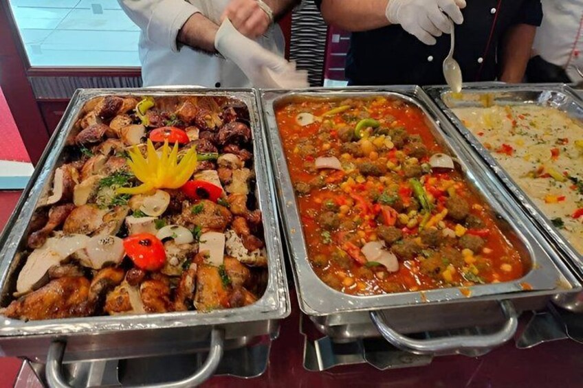 Un bufé con diversos platos, incluyendo carne, verduras y una opción de pasta. 2