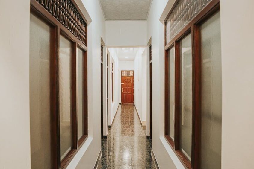 A hallway with wooden doors and a tiled floor. 2