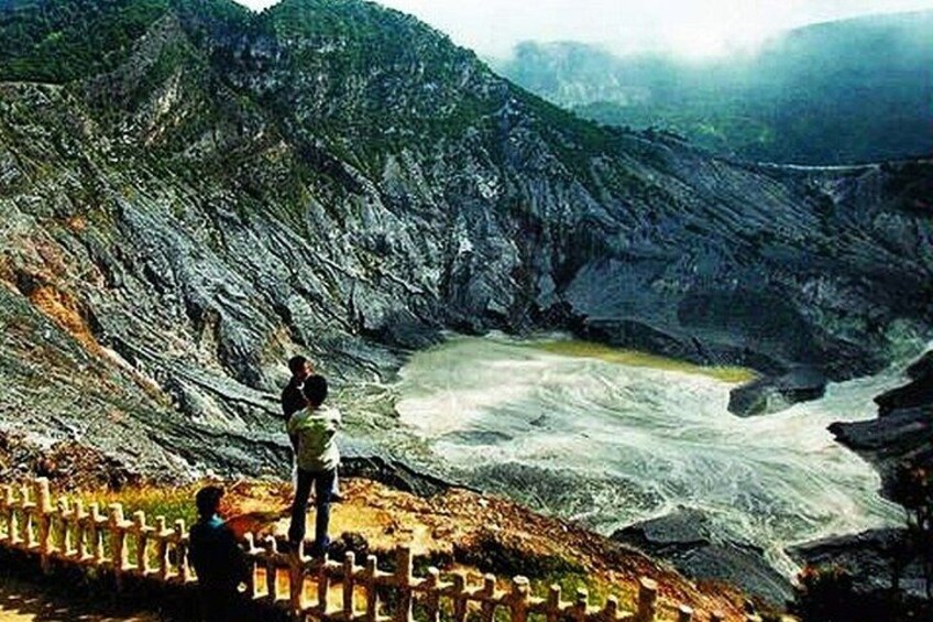 A person standing on a rocky ledge overlooking a river. 2